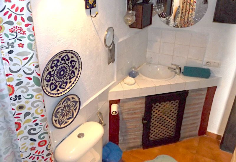 Duschraum mit Eckwaschbecken und Toilette.