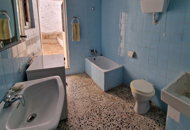 Oude badkamer met blauwe titels en oude apparatuur