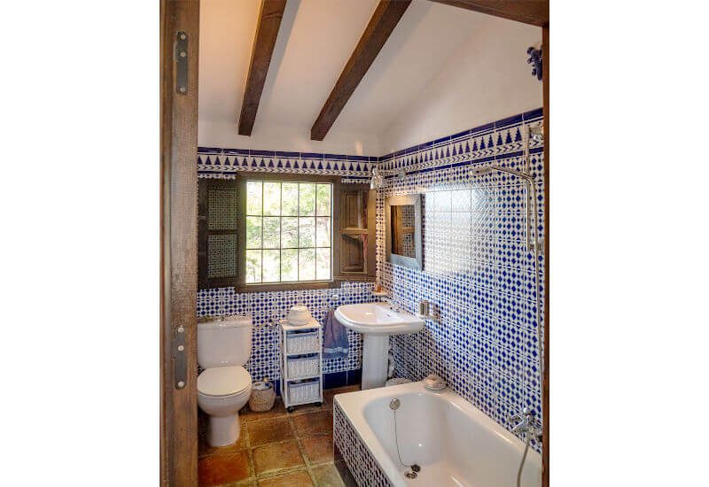Bathroom B has a large window and also a bathtub.