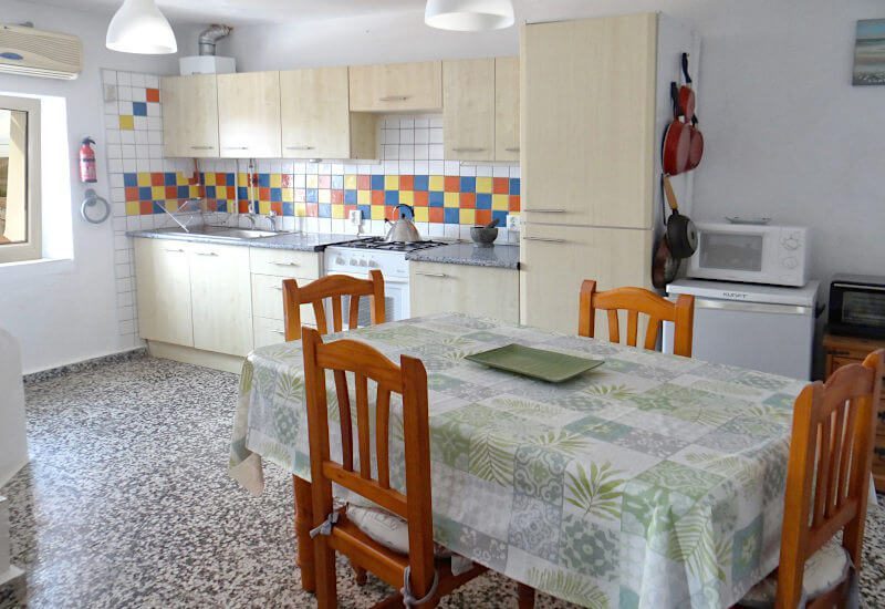 Voll ausgestattete Küche mit Esstisch und Fenster im typischen andalusischen Dorf