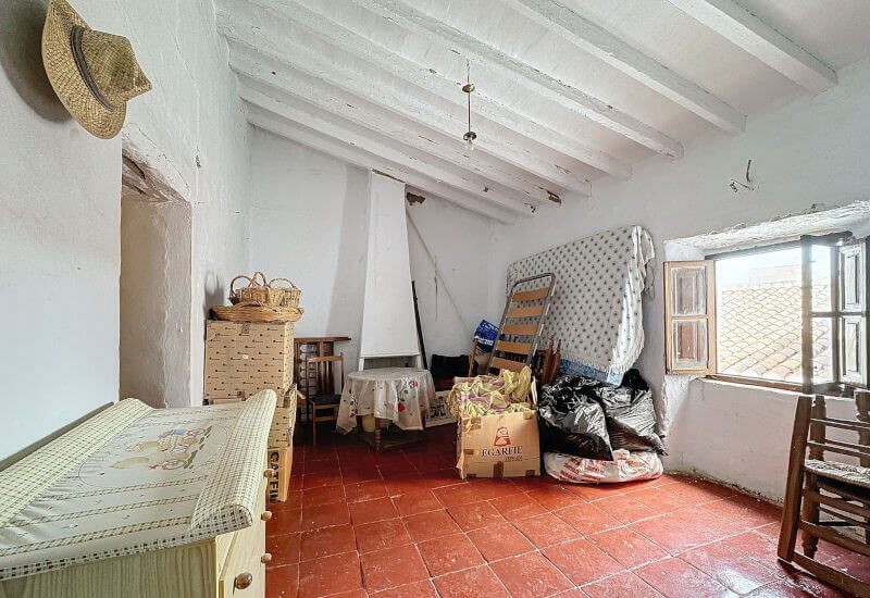 Im 1. Stock befindet sich ein Schlafzimmer mit Kamin, Fenster und traditioneller Decke