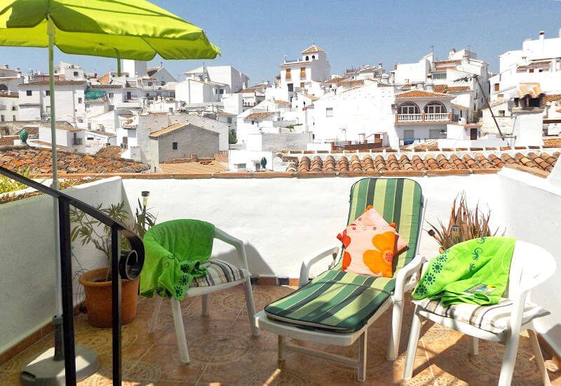 een terrasje met een lekker zonnetje over de daken van Sedella