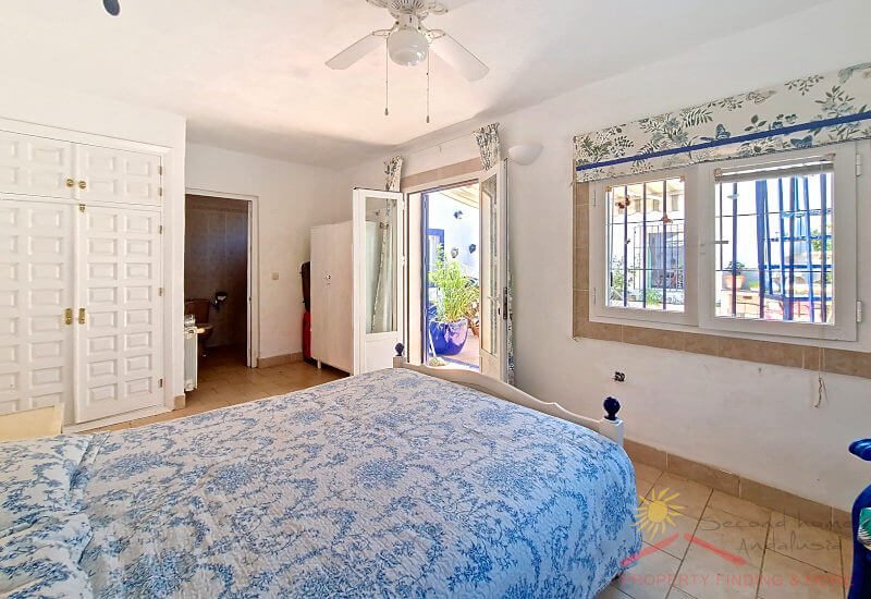 Das 2. Schlafzimmer mit breitem Bett hat Wandschränke 2 breite Fenster und eine Glastür zur Terrasse
