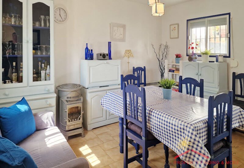 Eetkamer met tafel en bank en een houtkachel
