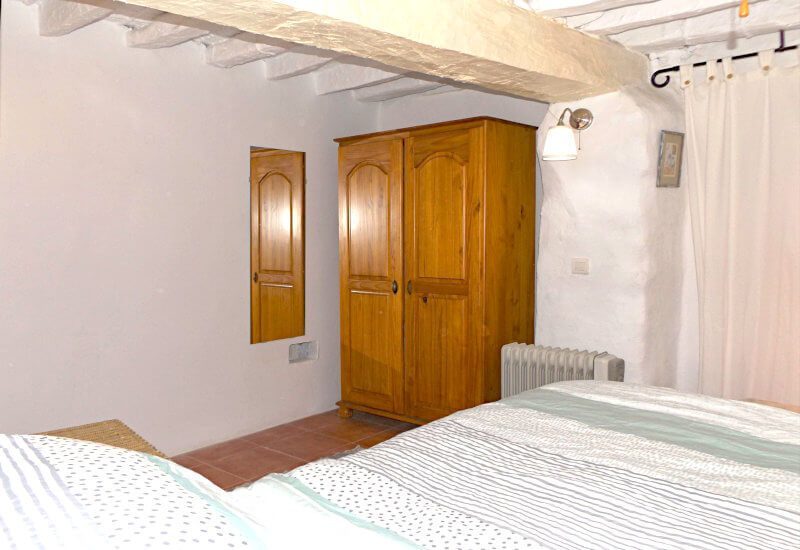 Gästezimmer mit Holzkleiderschrank und rustikaler Wand