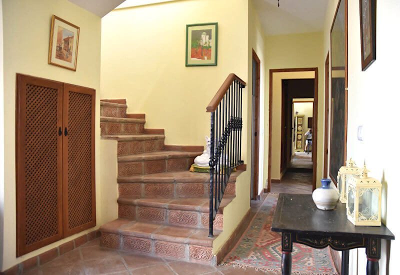 A stone staircase upwards and a hallway to the bedrooms