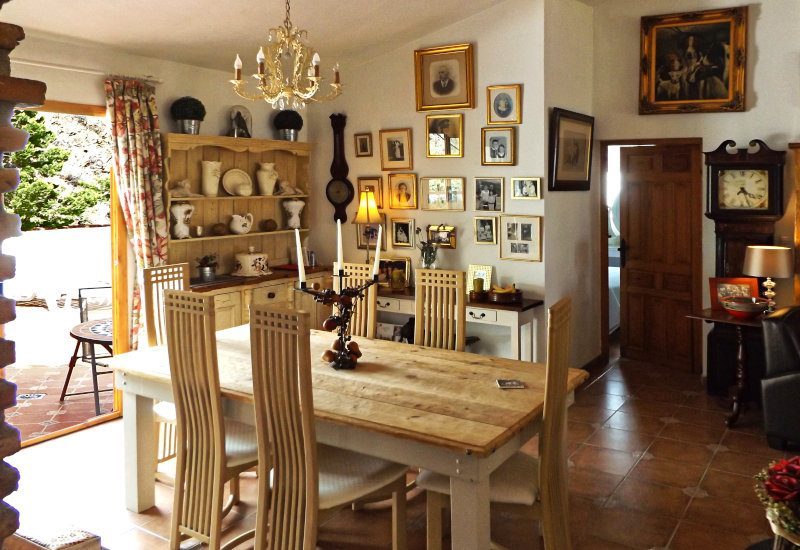 De eetkamer met houten tafel en buitendeur uit de woonkamer.