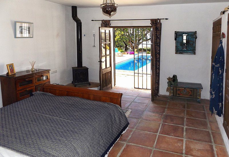 Photo of the master bedroom with terrace door and view on the pool.