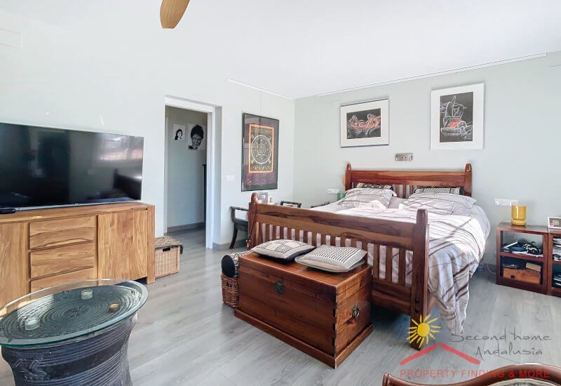 Large master bedroom with double bed and large TV