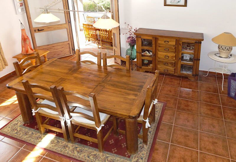 De eetkamer heeft een mooie houten tafel voor zes personen.