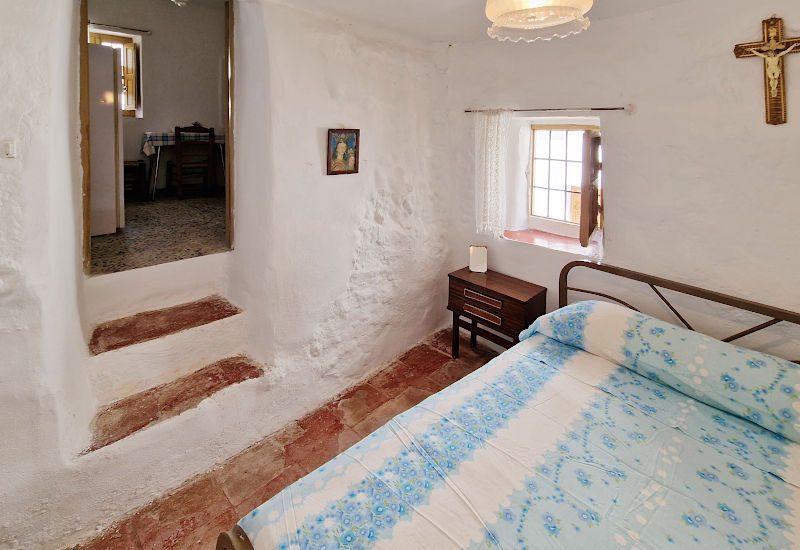 Slaapkamer 1 met een kingsize bed en twee trappen naar de keuken