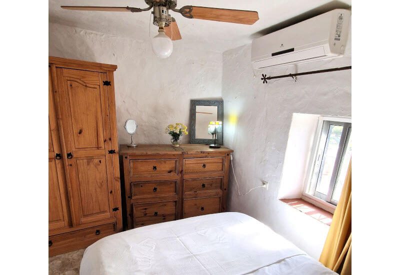 De gasten slaapkamer heeft een kledingkast, airconditioning en een plafondventilator.