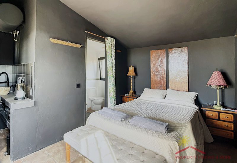 Casita Slaapkamer met tweepersoonsbed en deur naar de badkamer