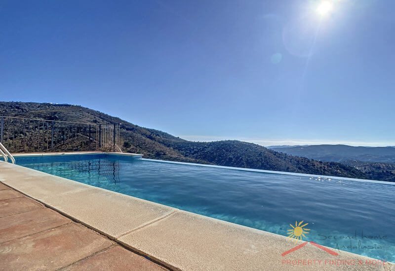 Vanuit het moderne overloopzwembad heb je een fantastisch uitzicht over de heuvels tot aan de zee van de Axarquía.