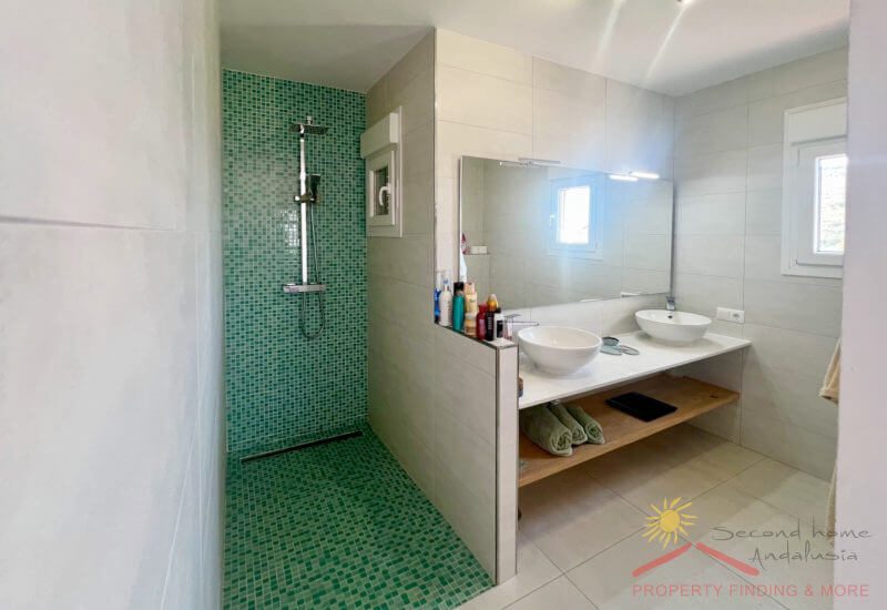 Gästebadezimmer mit Dusche, 2 Waschbecken und einem kleinen Fenster