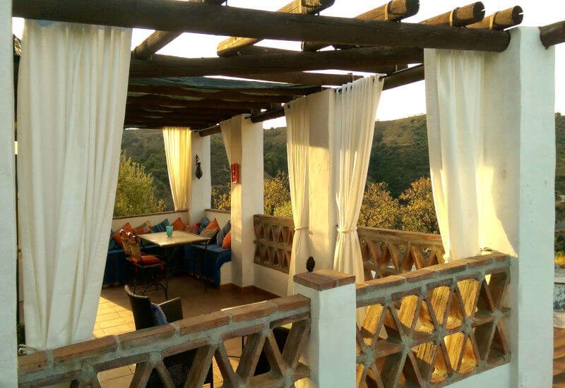 The upper terrace has a wooden framework and curtains