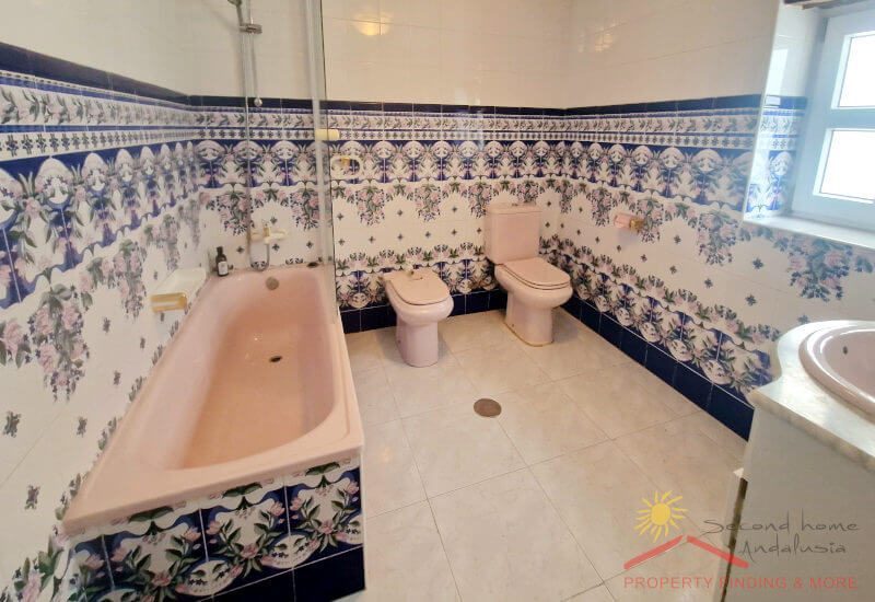 A large bathroom with bathtub, toilet, bidet and washbasin
