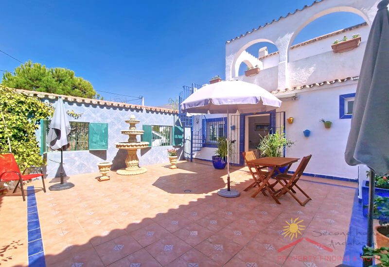 Large courtyard with fountain surrounded by the house and a wall to protect against the wind