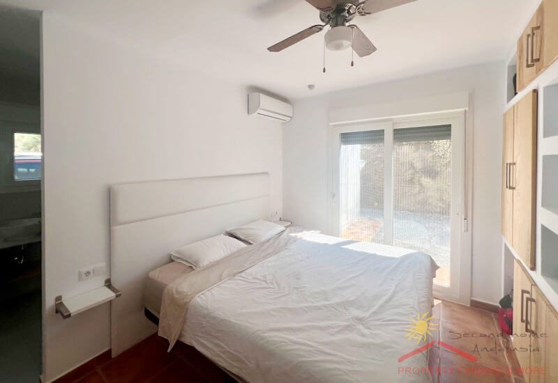 Hauptschlafzimmer mit Doppelbett und Einbauwand, sowie grosse Glastüren zur Terrasse