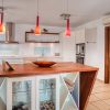 Keuken Een houten bar met ingebouwde vitrine verdeelt de keuken.