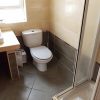 Ensuite badkamer Ensuite badkamer met toilet, douche en een klein raam.
