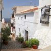 An old typical Andalusian village street leads to the house