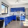 De keuken van het appartement is modern, volledig uitgerust met een intensieve blauwe