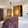 Bovenste slaapkamer Een grote slaapkamer met tweepersoonsbed en rustieke inrichting