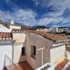 Aussicht Blick von der Terrasse über die Dächer des weißen Dorfes Sedella mit Maroma im Hintergrund