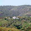 Distant view Casa Churrispa in the campo of Sedella from a distant surrounded by green trees and bushes