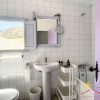 Badezimmer mit Badewanne, Toilette und Waschbecken und einem kleinen Fenster