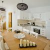 Modern bright kitchen, fully equipped, with dining table and windows to the street