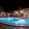 Lighted pool on the terrace in front of the house.