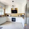 a big modern light white kitchen with a window and a door to the terrace