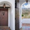 Chic entrance door made of wood in Moroccan style, from the entrance there is a phantastic view on the hills of the Axarquia