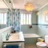 Grote badkamer met raam, een buis, toilet en wastafel met groene tegels