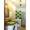 The green bathroom si tiled in green and has a shower