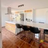 Keuken Moderne ingerichte keuken met kookeiland en eettafel voor 7 personen