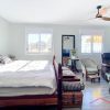 Large, bright master bedroom with double bed and seating area
