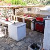 Outdoor kitchen with sink and barbecue in the paved courtyard